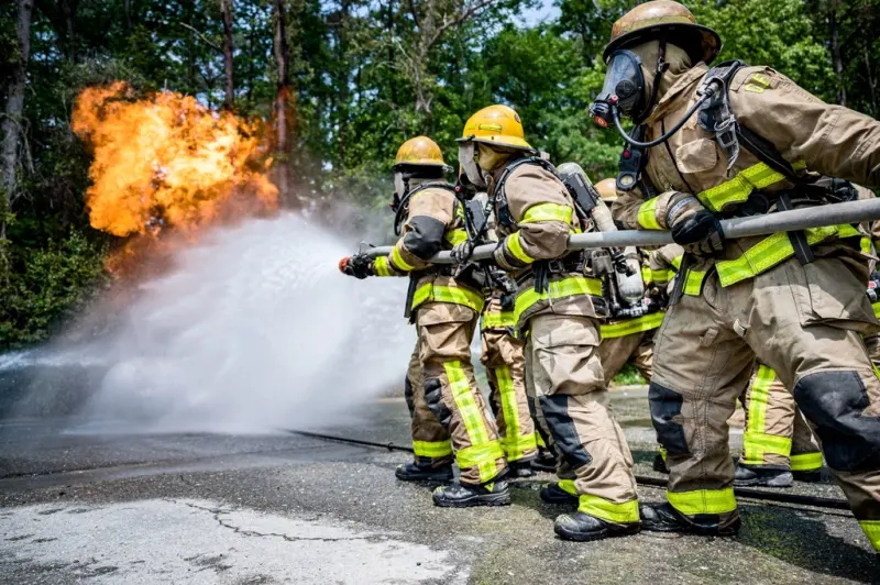 Fire fighters training with a hose during a live drill
