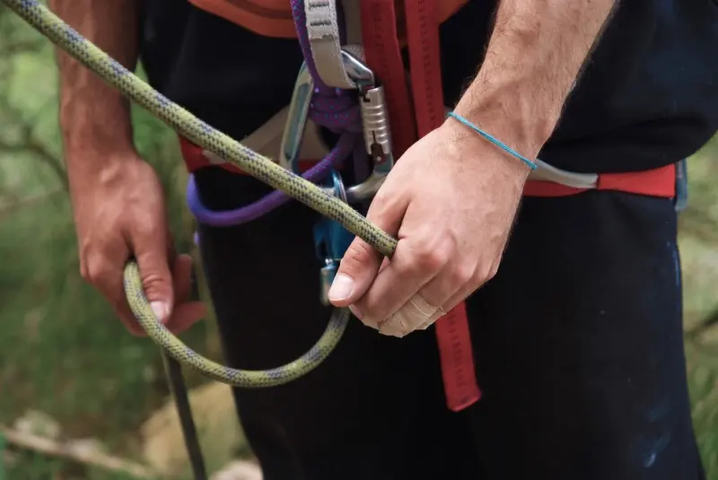 Worker adjusting a rope on a full-body harness